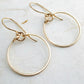 Gold hoop earrings on a light gray surface