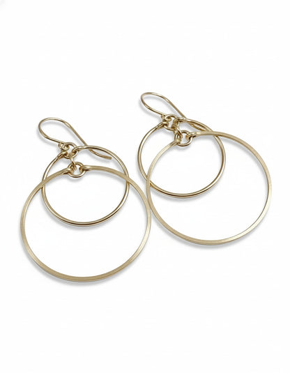 Silver hoop earrings on a light gray fabric background