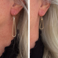 Side-by-side comparison of gold tear drop earrings worn by a person with light hair.