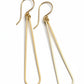 Pair of gold earrings on a light gray surface