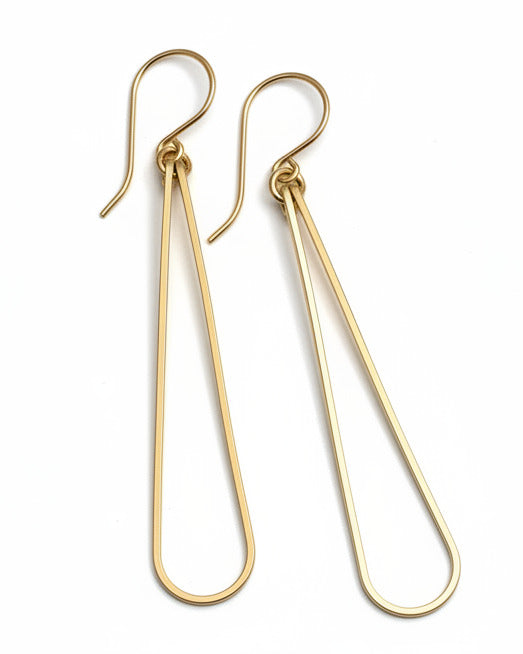 Pair of gold earrings on a light gray surface