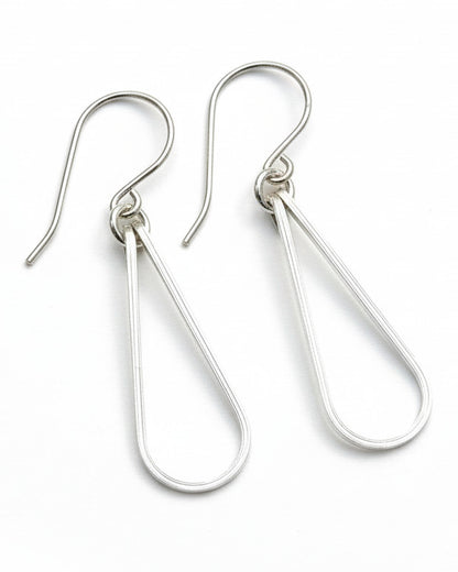 Pair of silver teardrop earrings on a gray background