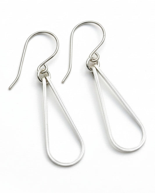 Pair of silver teardrop earrings on a gray background