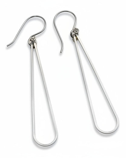 Pair of silver teardrop earrings on a gray background