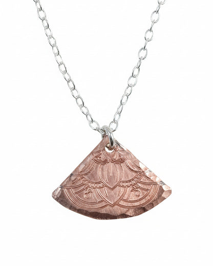Copper pendant necklace on a light gray background