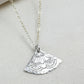 silver necklace with a half-circle pendant on a light fabric background