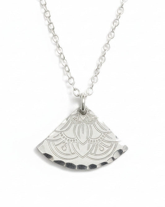 Silver necklace with a decorative pendant on a light gray background
