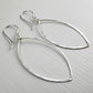 Pair of silver teardrop earrings on a light gray background