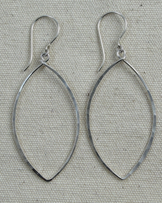 Pair of silver hoop earrings on a textured gray background