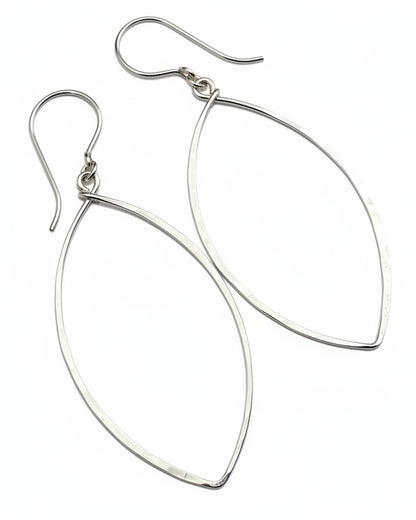 Silver teardrop earrings on a textured gray surface