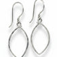 Pair of silver earrings on a textured beige background