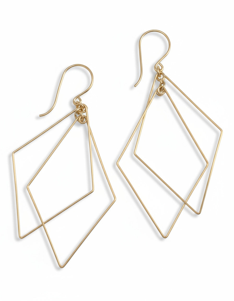 Pair of silver geometric earrings on a light gray background